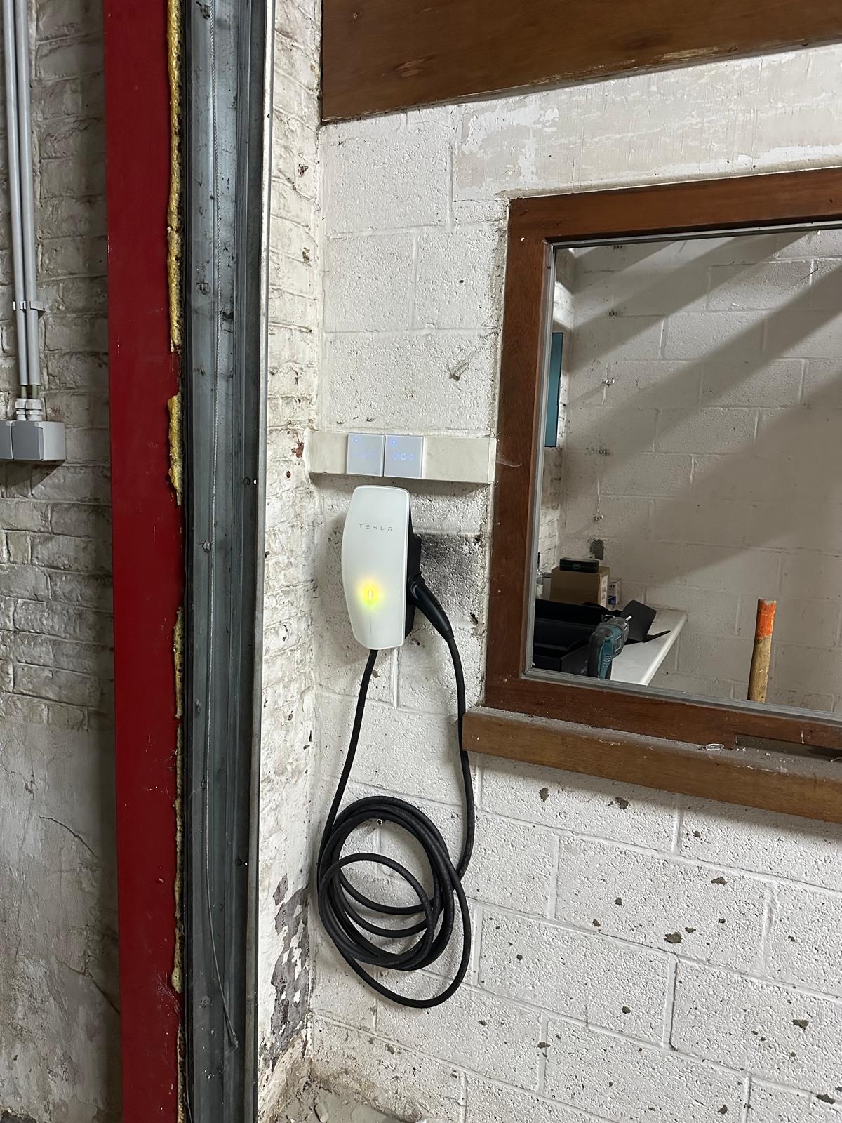 Borne de recharge Tesla installée au mur par Farhan Energy